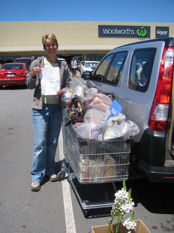 Inga with her grocery list and an overflowing cart at "Woolies"