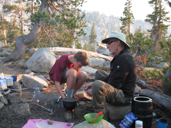 Chase helps Steve fill the wood-burning camp stove. 