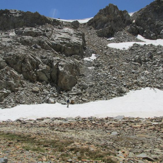 Snowfield under band of rock with thin cornice visible at top