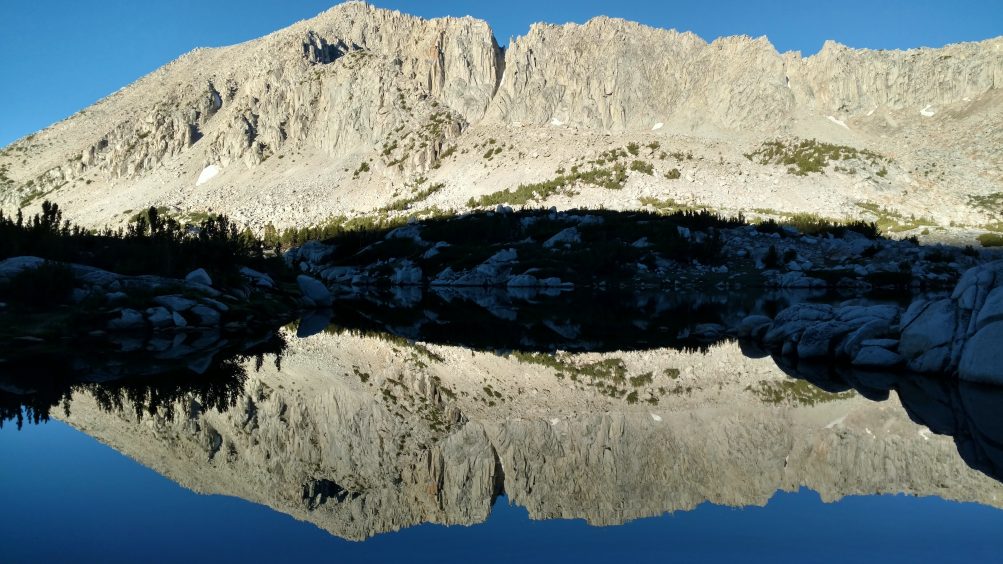 Granite mountain with reflection in blue lake
