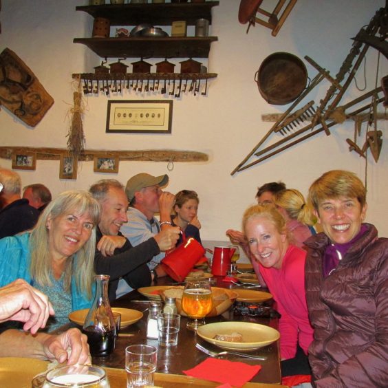 Group of people dining in rustic cabin. 