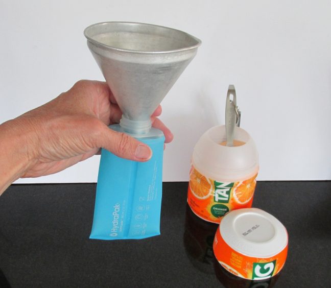Funnel set in flask to pour Tang orange drink powder