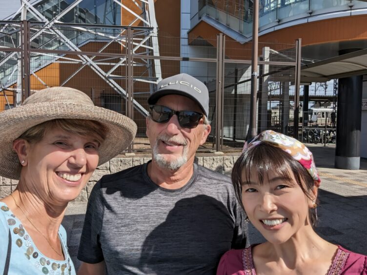 Woman, man and Bell, the teacher, outside of a train station