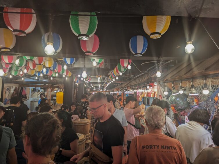Crowded scene of tourists packed into a covered market