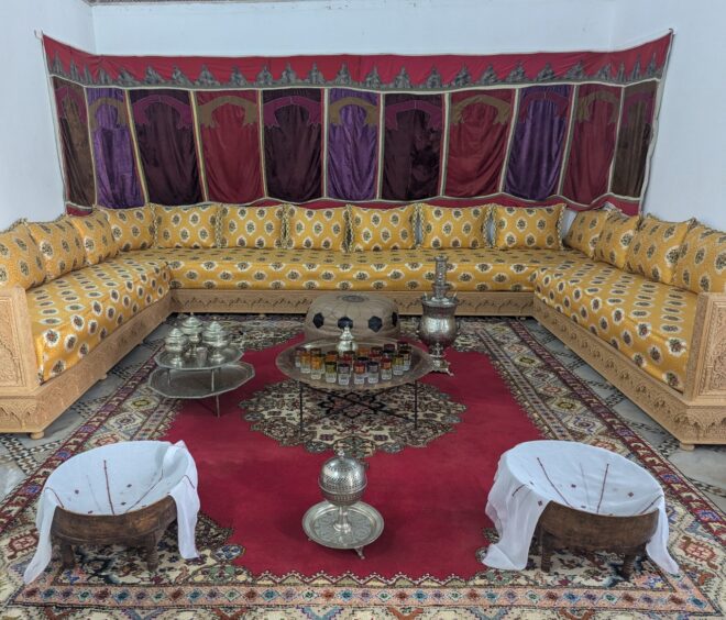 Fancy room with yellow U-shaped sofa and serving trays on stands