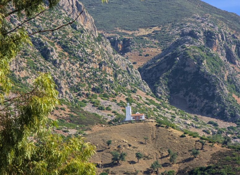 Vast mountain scene with a small white mosque in the center