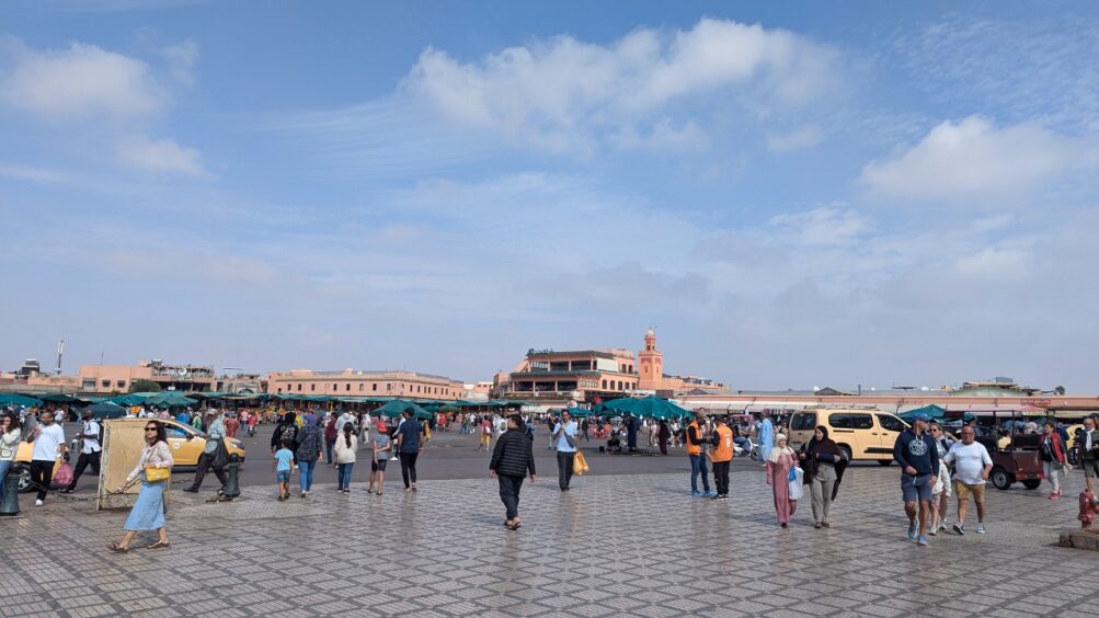 Large square with many people in front of a medina