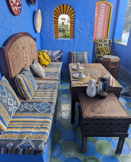 Bright blue sitting area with blue walls, floor and patterned cushions