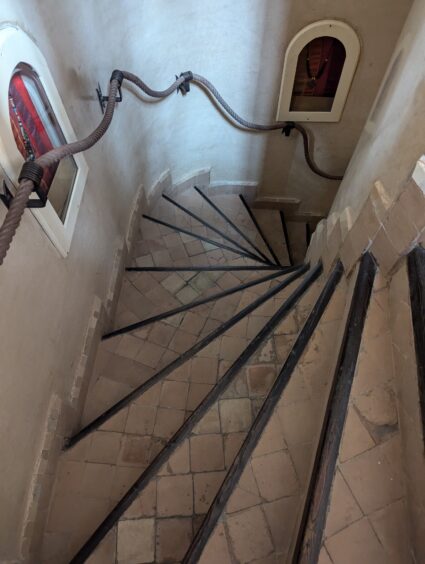 Narrow, spiral staircase with rope railing