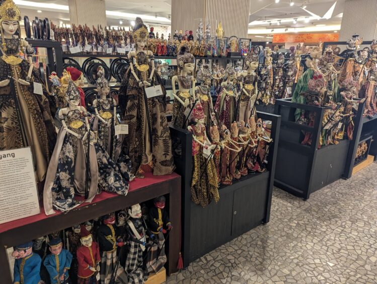 A store display with many wooden puppets