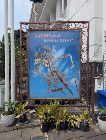 A large blue sign showing a flat leather puppet at the Wayan Museum