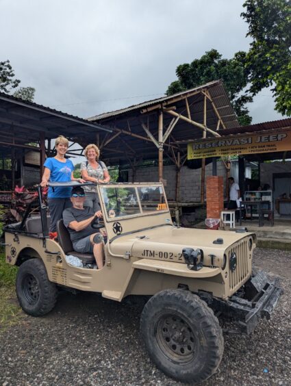 Author, friend and husband pose in the battered jeep used for a jeep tour