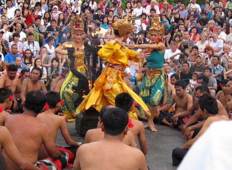 3 traditional dancers in front of a packed crowd