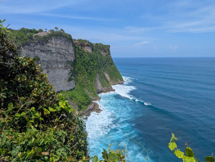 Massive cliffs with surf below
