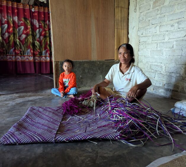 Indonesian woman weaving a pandanus mat