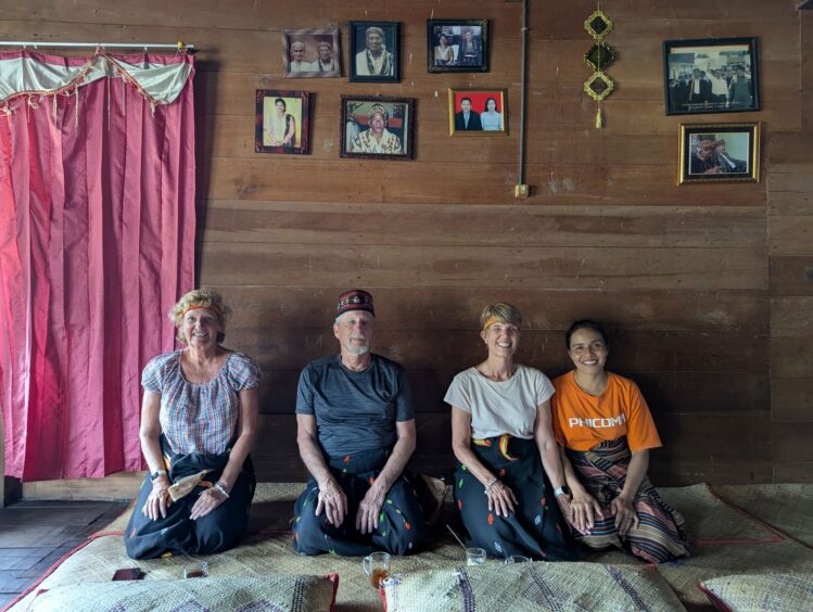 Author, her husband and friend kneeling with chief's wife