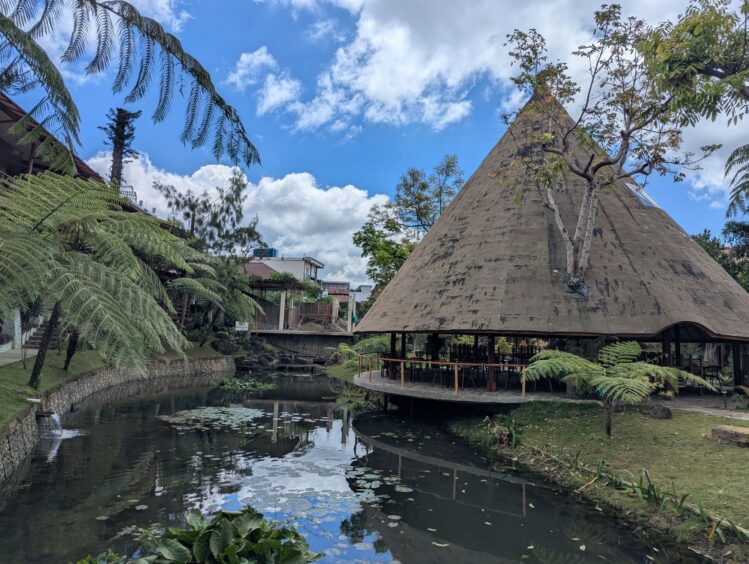 Hotel with thatch building and pond